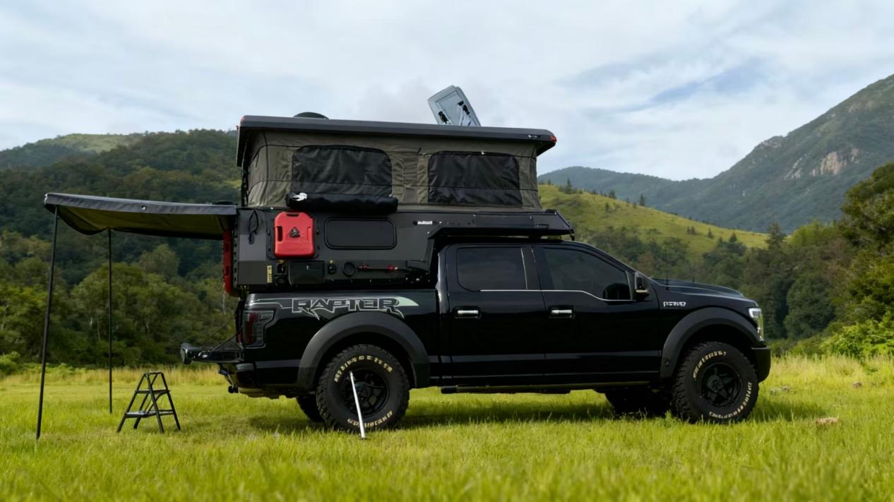 Black off-road pop-up truck camper with side awning